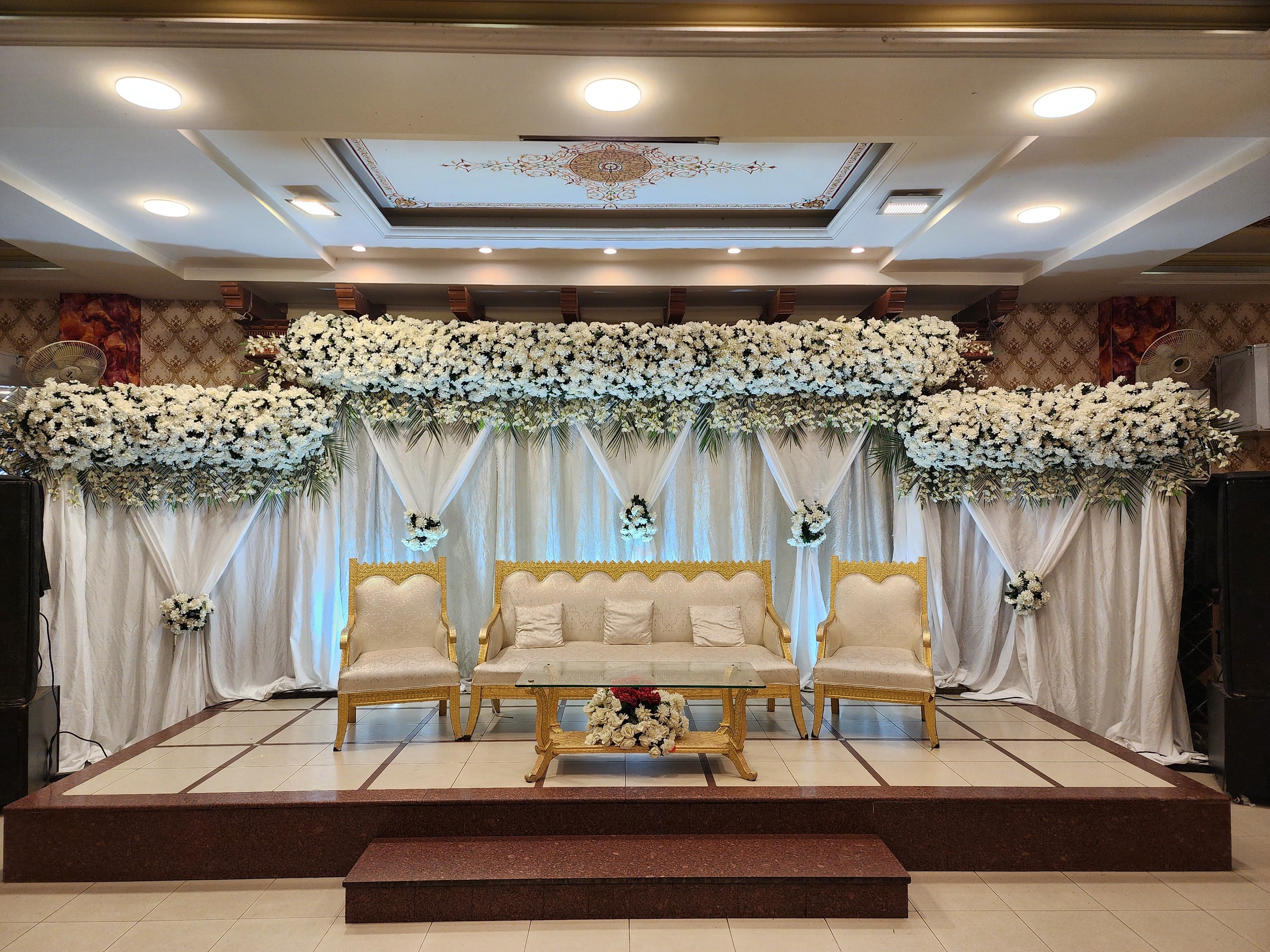 The ground floor hall at Naulakha, with a white and gold flower stage set for a wedding